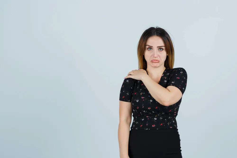Woman holding shoulder due to pain during household activity