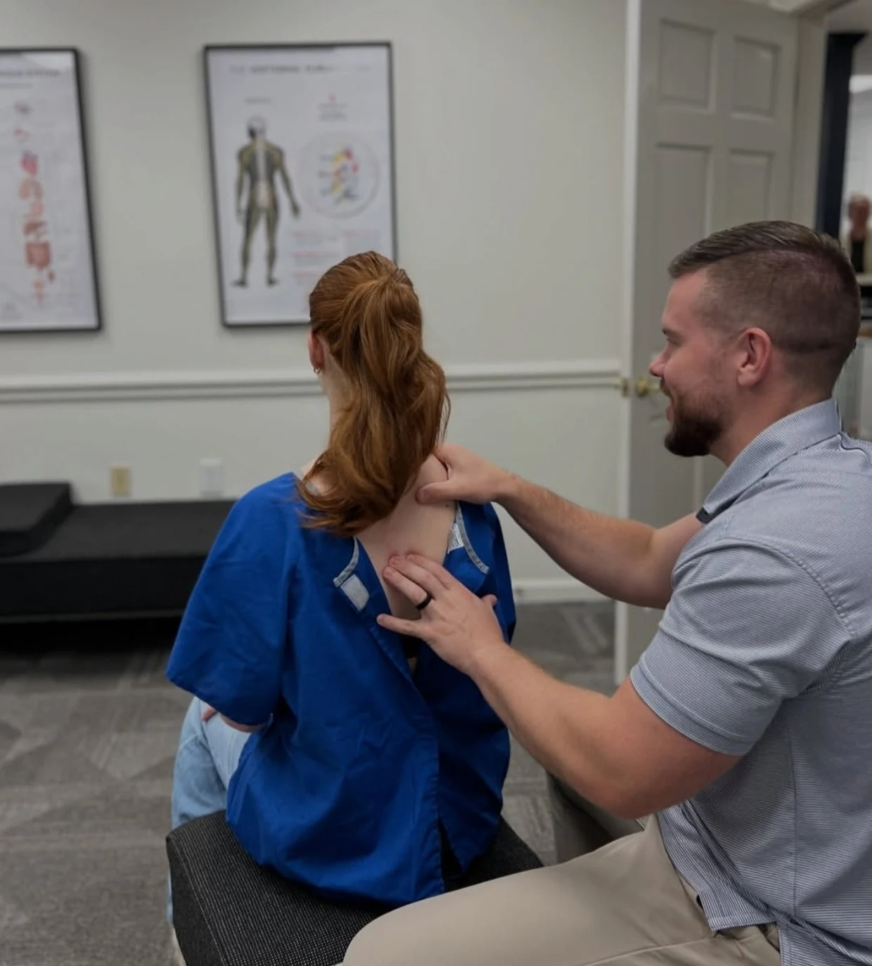 Chiropractor performing an upper back and thoracic spine evaluation during a patient visit at Axiom Chiropractic in Charlotte NC