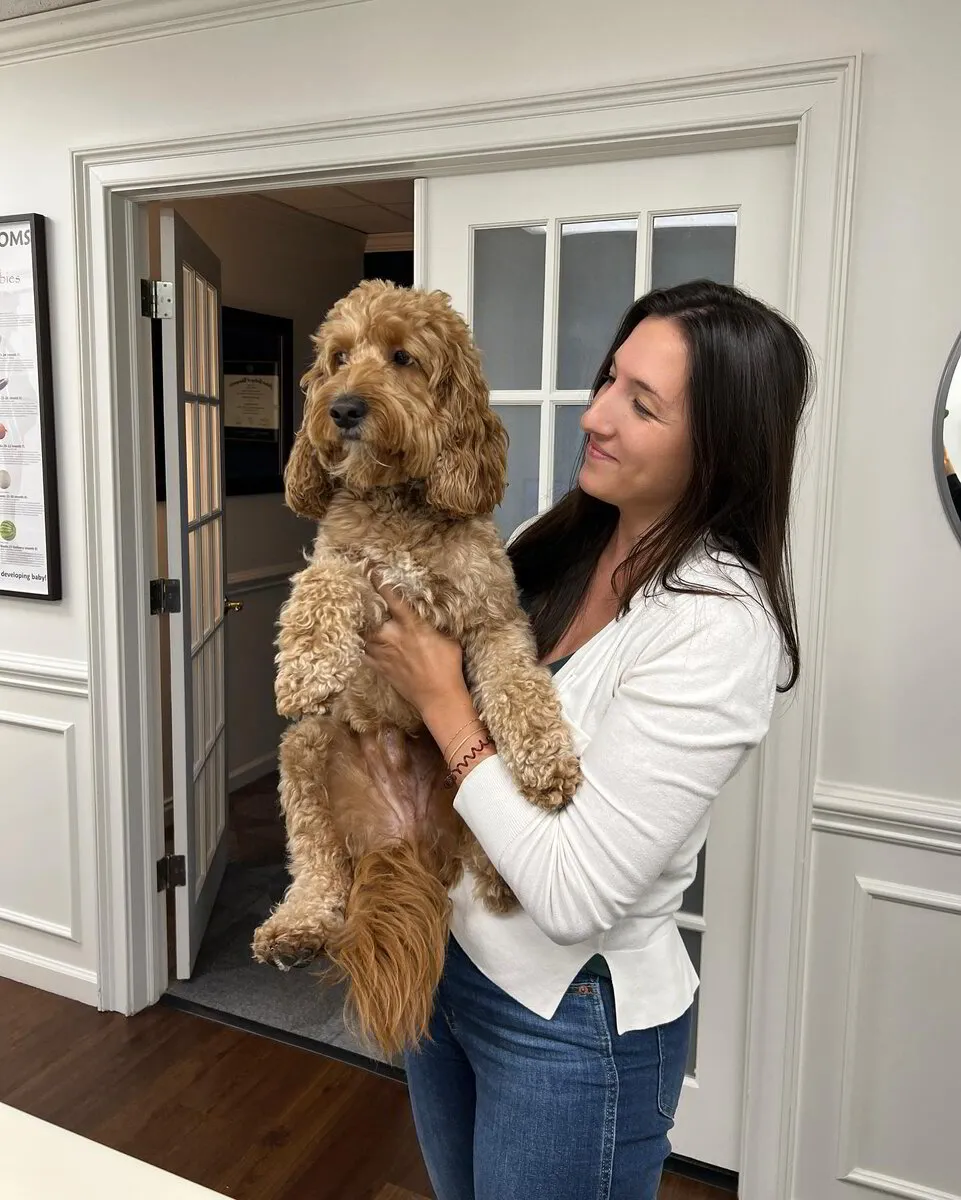 Chiropractor holding sweet pet puppy animal at Axiom charlotte