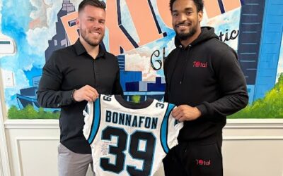 Dr. Tyler with Axiom Chiropractic with professional football player holding his jersey