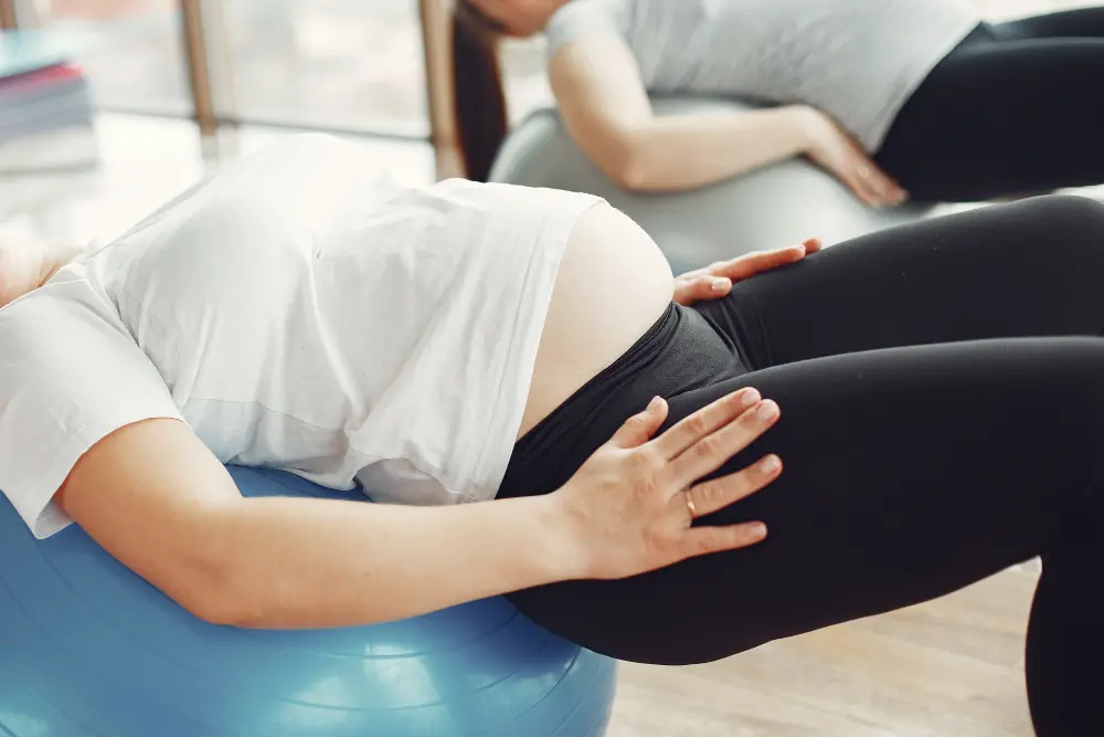 Pregnant woman performing stability ball exercise for prenatal wellness