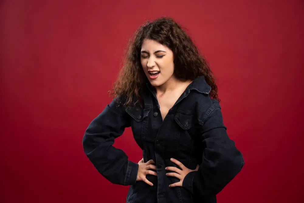 Woman standing while holding abdomen due to digestive issues