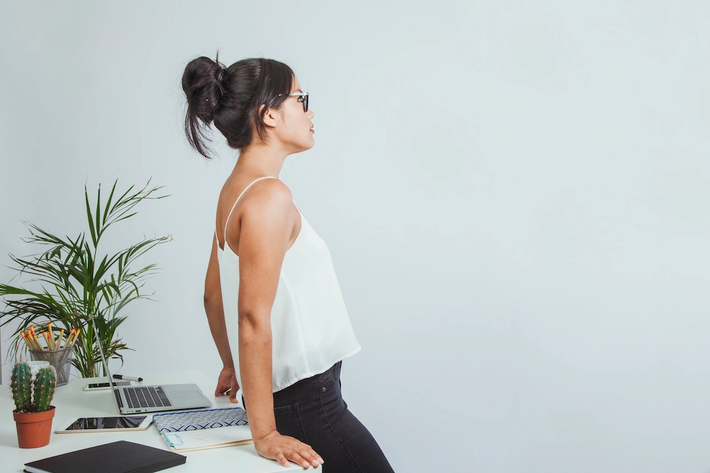 Office worker showing poor posture while sitting at desk