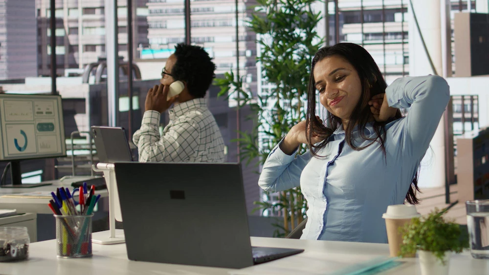 Office worker holding neck due to tech neck from prolonged screen use
