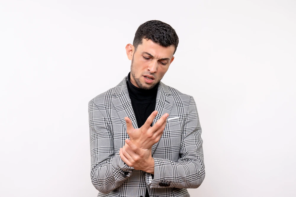Person experiencing wrist pain and tingling fingers while working at a desk